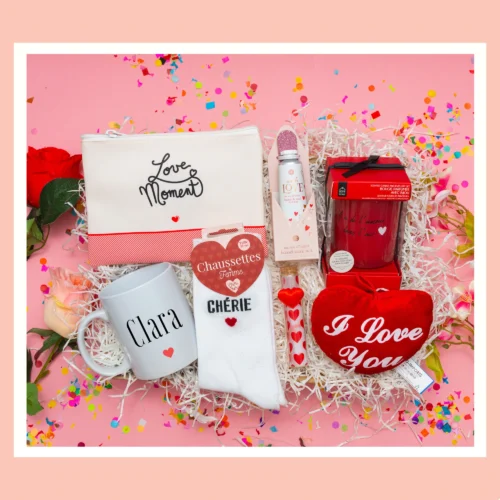 Cadeau pour copine dans un coffret romantique qui inclut une pochette Love Moments, mini peluche cœur 'Love You', bougie bijou avec message romantique, tasse personnalisée et crème pour les mains.